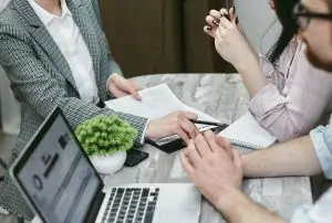 Szerződéskötés megbeszélés közben – laptop és dokumentumok az asztalon